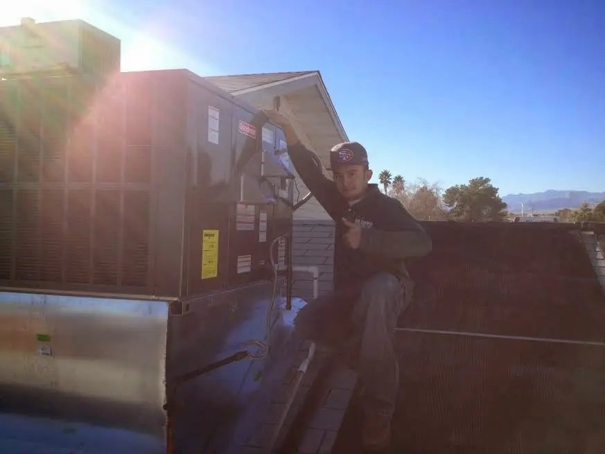 HVAC technician performing HVAC Inspection on a rooftop unit in Bedford
